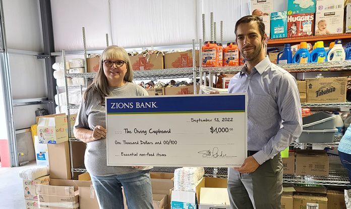 Zions Rigby branch manager David Hosmer with Cheryl Hively Pay it Forward Director a division of the Giving Cupboard